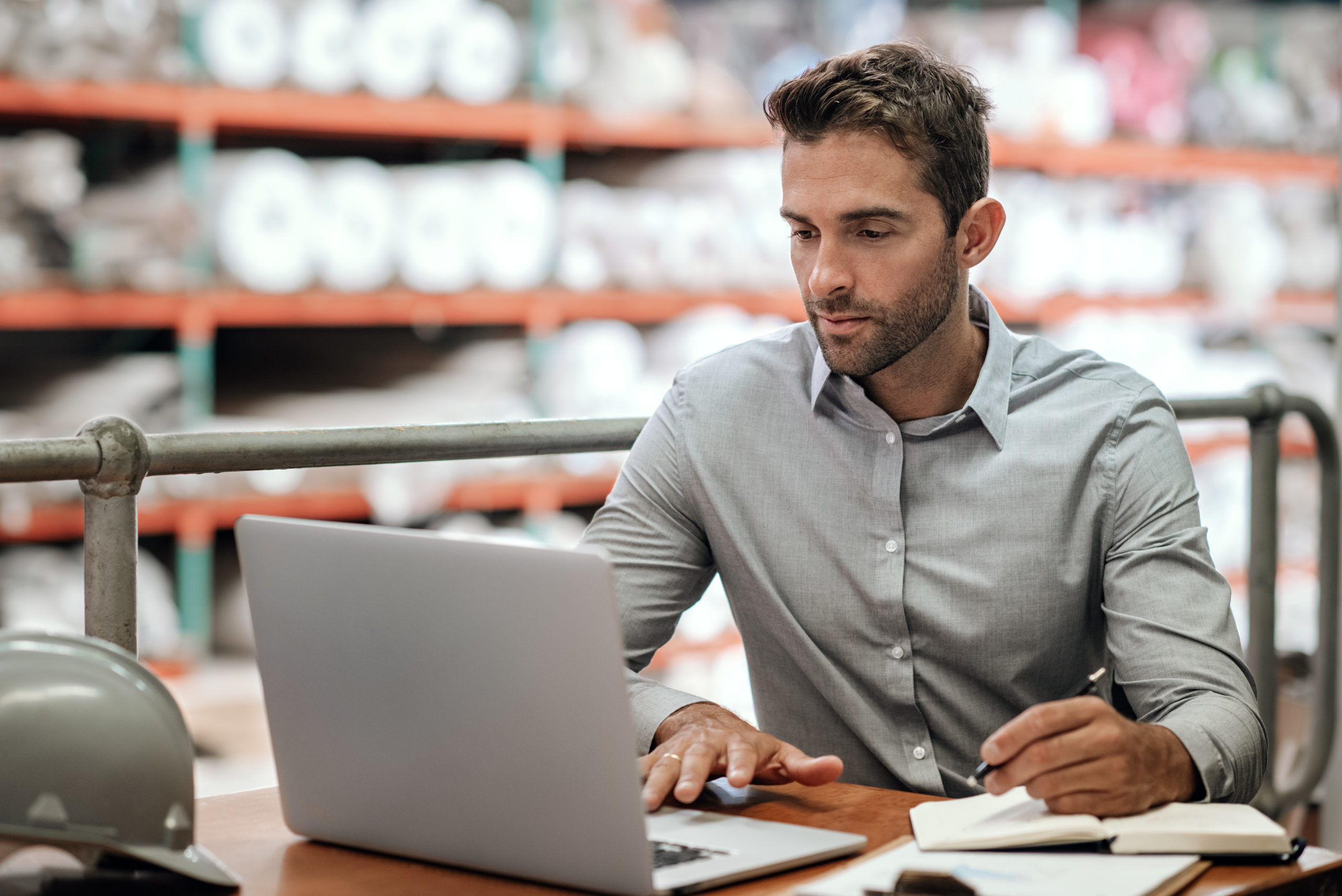 Assistant approvisionnement dans un magasin logistique du laboratoire devant un ordinateur